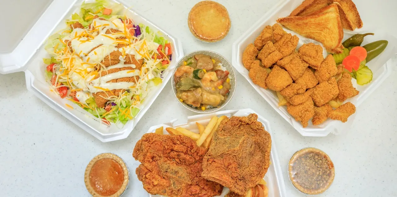 A spread of Ronnie's catfish baskets, salad, sauces and sides
